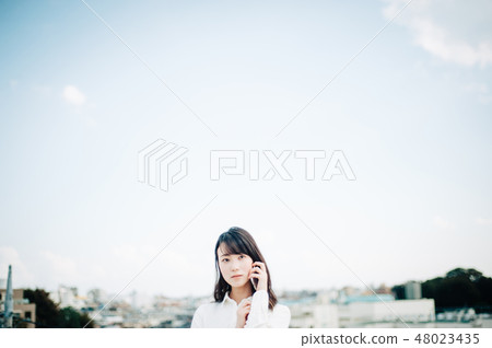 一件白襯衫的女人在屋頂上打電話 48023435