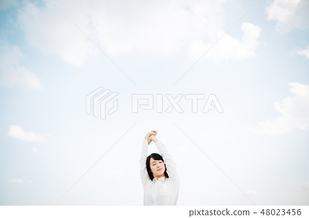 A woman in a white shirt standing on the roof 48023456