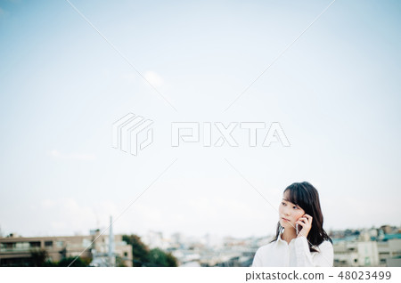 一件白襯衫的女人在屋頂上打電話 48023499