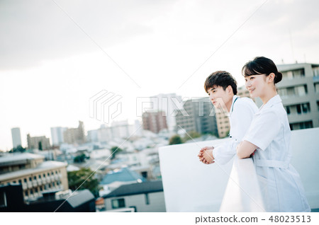 Men and women wearing white robes lined up on the roof Men and women wearing white robes lined up on the roof 48023513