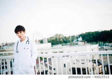 A man wearing a white suit on a roof railing A man wearing a white suit on a roof railing 48023515