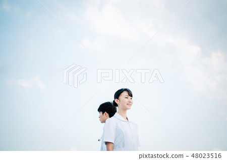 Back-to-back man and woman in a white robe standing on the roof Back-to-back man and woman in a white robe standing on the roof 48023516