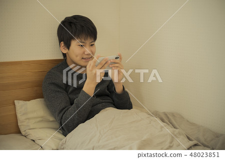 A boy who uses smartphone in bed sleep sleepy junior high school student high school student A boy who uses smartphone in bed sleep sleepy junior high school student high school student 48023851