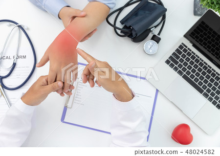 Doctor explain wrist pain symptoms to patient Doctor explain wrist pain symptoms to patient 48024582