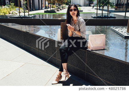 female customer sitting near the fountain pool female customer sitting near the fountain pool 48025786