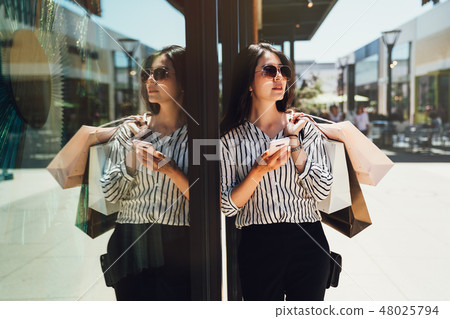 young lady carrying shopping bag in shopping mall 48025794