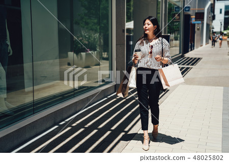 charming girl walking on street window shopping 48025802