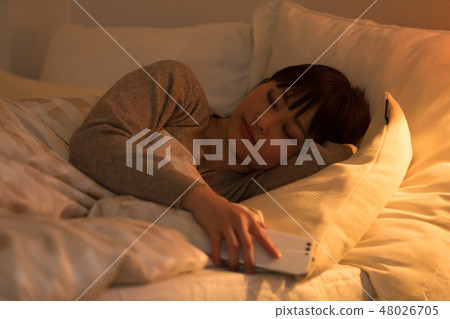 A woman sleeping in bed A woman sleeping in bed 48026705
