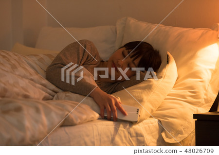 A woman sleeping in bed A woman sleeping in bed 48026709