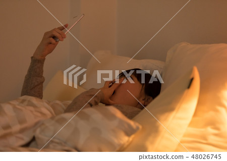 A woman sleeping in bed A woman sleeping in bed 48026745