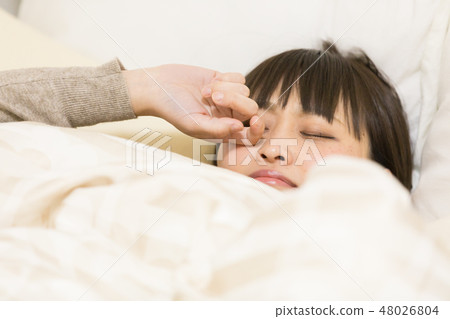 A woman sleeping in bed A woman sleeping in bed 48026804