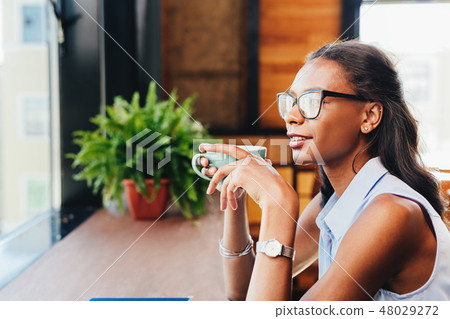 Woman sitting at cafe and looking away  48029272