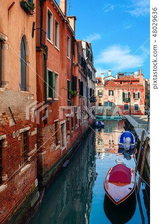 Narow canal with boats in Venice, Italy. 48029636
