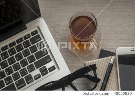 One glass of tea and work equipment 48030920