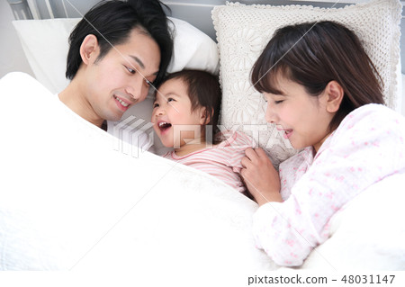 Young family entering the bed 48031147
