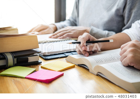 High school tutor or college student group sitting at desk in li 48031403