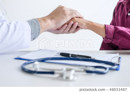 Doctor touching patient hand for encouragement and empathy on th 48031487