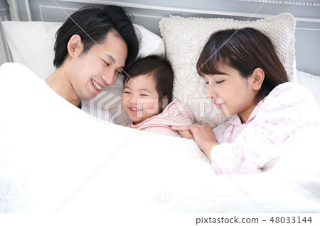 Young family entering the bed 48033144
