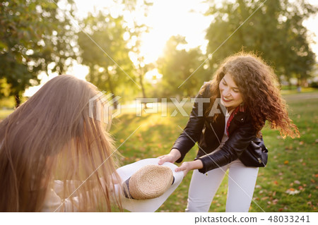Outdoors portrait of two merry young woman.  48033241