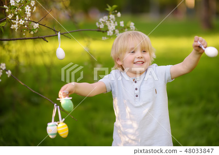 Cute little boy hunts for easter egg Cute little boy hunts for easter egg 48033847