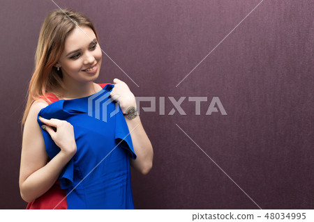 The girl in the fitting room chooses a dress. 48034995
