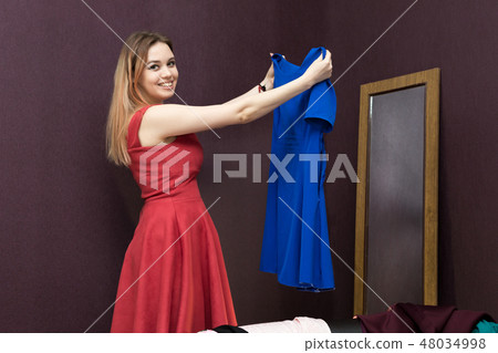 The girl in the fitting room chooses a dress. The girl in the fitting room chooses a dress. 48034998