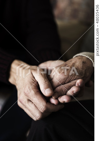 young man holding the hand of an old woman 48035436