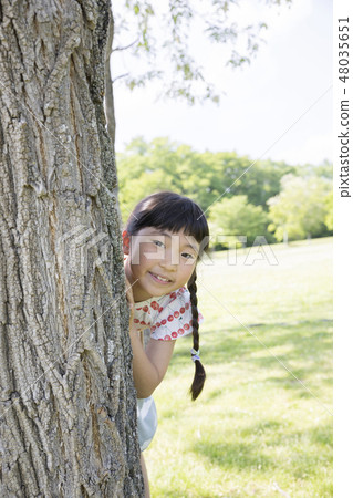 Child with face from tree shade 48035651