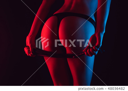 Sexy erotic ass of a girl in a Thong with a whip for BDSM 48036482
