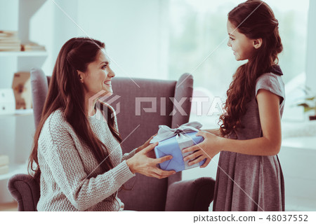 Positive girl presenting a gift for her mother 48037552