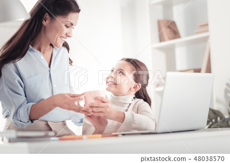 Caring tender mother bringing daughter cup of tea to her child room 48038570