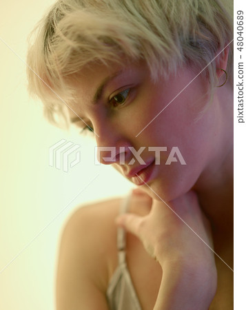 Close-up of pensive blondy looking down thinking 48040689