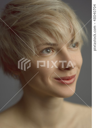 Modest woman smiling and looking up 48040704