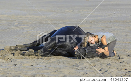 woman and horse on the beach 48041297