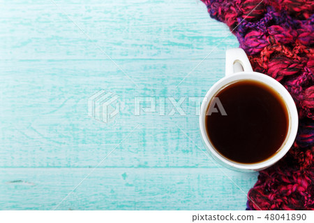 cup of hot black tea with steam in knitted scarf. cup of hot black tea with steam in knitted scarf. 48041890