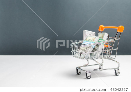 Supermarket cart with packs of dollars Supermarket cart with packs of dollars 48042227