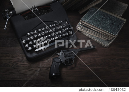 Crime fiction old retro vintage typewriter and gun Crime fiction old retro vintage typewriter and gun 48043082