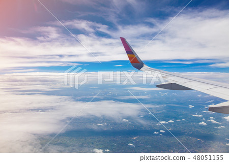 Aircraft Wing on blue sky and clouds background. Aircraft Wing on blue sky and clouds background. 48051155