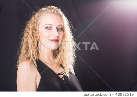 People and fashion concept - Portrait of sexy beautiful blond lady model in black dress standing on People and fashion concept - Portrait of sexy beautiful blond lady model in black dress standing on 48051519