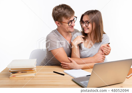 Education, people and relationship concept - a couple of students is hugging, because they are tired Education, people and relationship concept - a couple of students is hugging, because they are tired 48052094