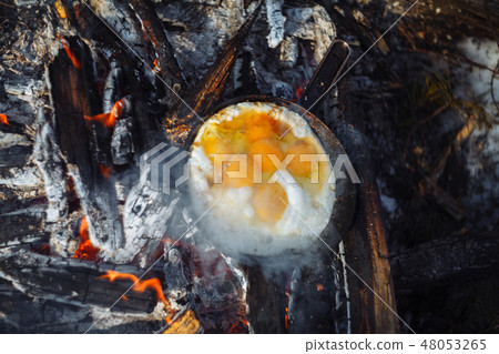 Fried eggs on the pan on the fire in winter Fried eggs on the pan on the fire in winter 48053265