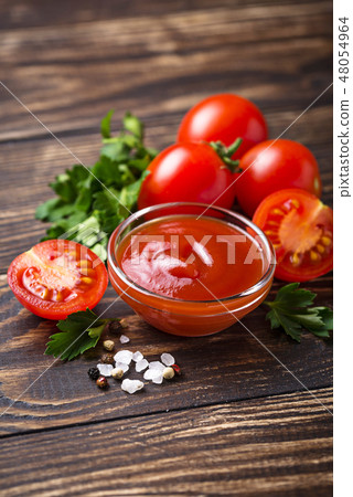 Tomato ketchup sauce on wooden background Tomato ketchup sauce on wooden background 48054964