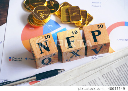 Text "NFP" on wood cube with gold bar on document Text "NFP" on wood cube with gold bar on document 48055349