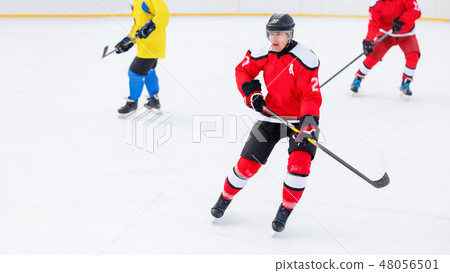 Male hockey player playing game on the rink Male hockey player playing game on the rink 48056501