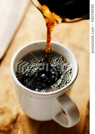 咖啡倒入一個杯子裡 48059098