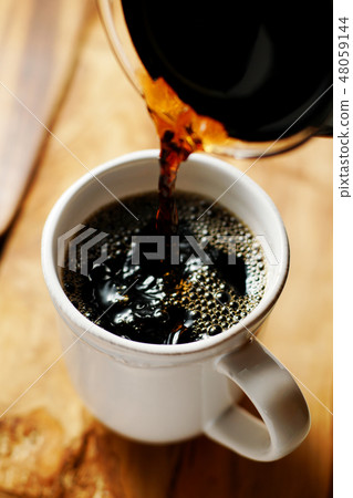 咖啡倒入一個杯子裡 咖啡倒入一個杯子裡 48059144