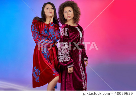 Beautiful models in bright red dresses with embroidery. 48059659