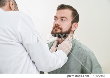 Bearded handsome man having neck and lymph nodes checked. 48059819