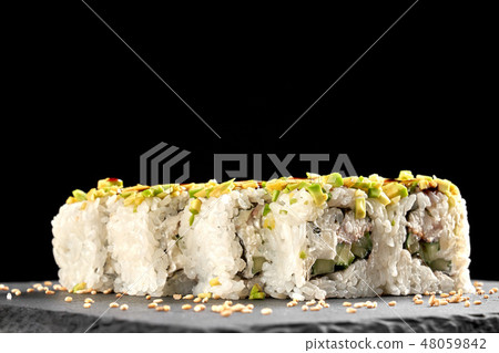 Japanese sushi roll covered with chopped avocado. 48059842