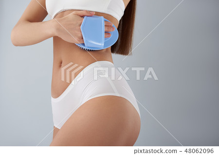Young lady in classic white underwear using massage brush 48062096